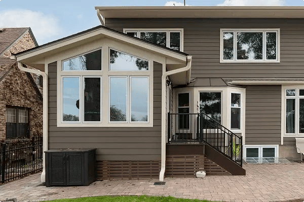 Minnesota home addition with gray board and batten siding, large picture windows, and covered entry steps
