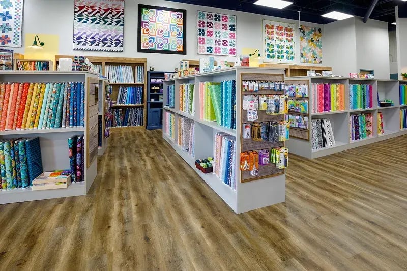 Minnesota retail build-out for a quilt shop featuring colorful fabric displays, open shelving, and quilts displayed on walls