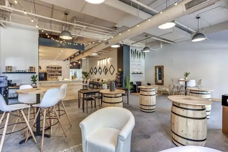 Commercial café build-out with barrel tables, open exposed ceiling, and service bar area completed by Titus Contracting in Minnesota