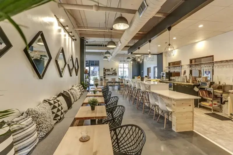 Commercial restaurant interior build-out with banquette seating, bar counter, and industrial pendant lighting by Titus Contracting