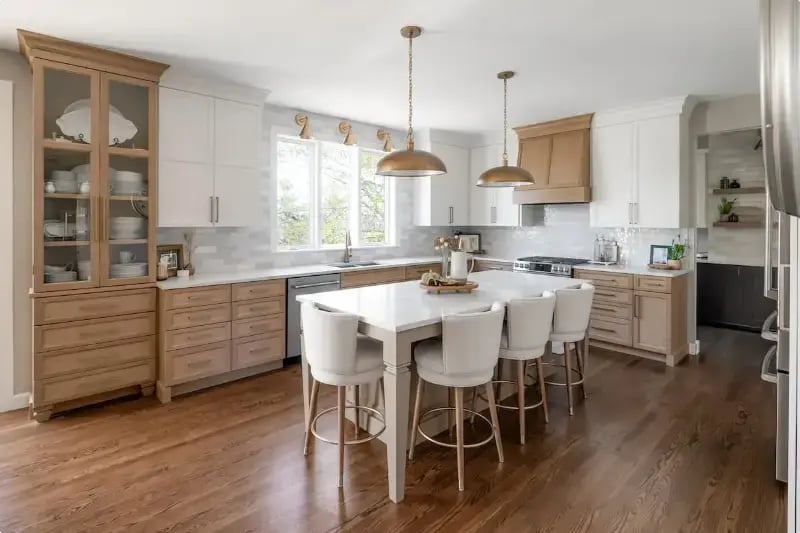 Luxury kitchen remodel with white oak lower cabinets, white upper cabinets, quartz island, and gold dome pendant lights by Titus Contracting