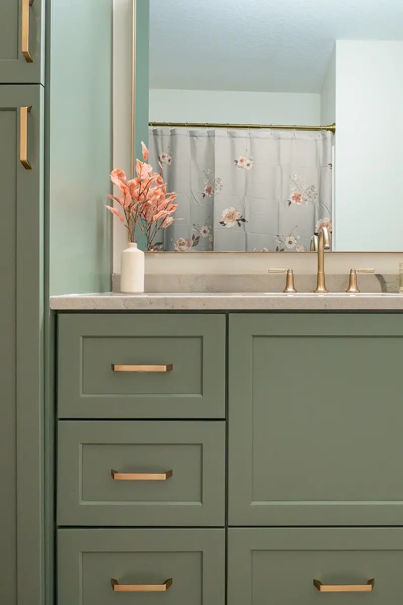 Detail of sage green bathroom vanity with quartz countertop and brushed gold hardware in a Minnesota bathroom remodel