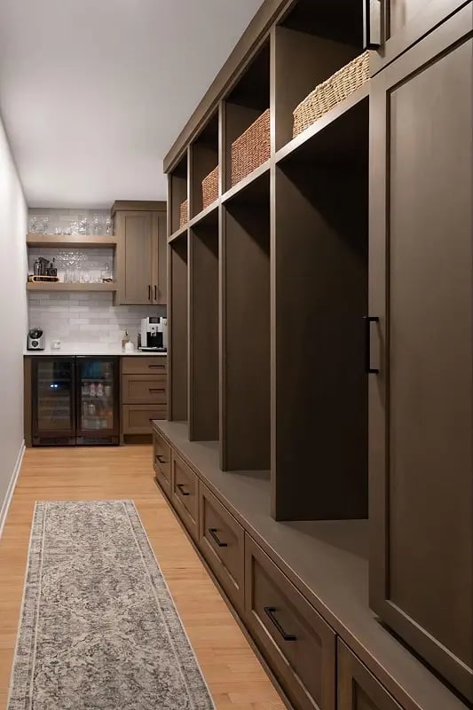 A modern brown mudroom with cubbies for jackets