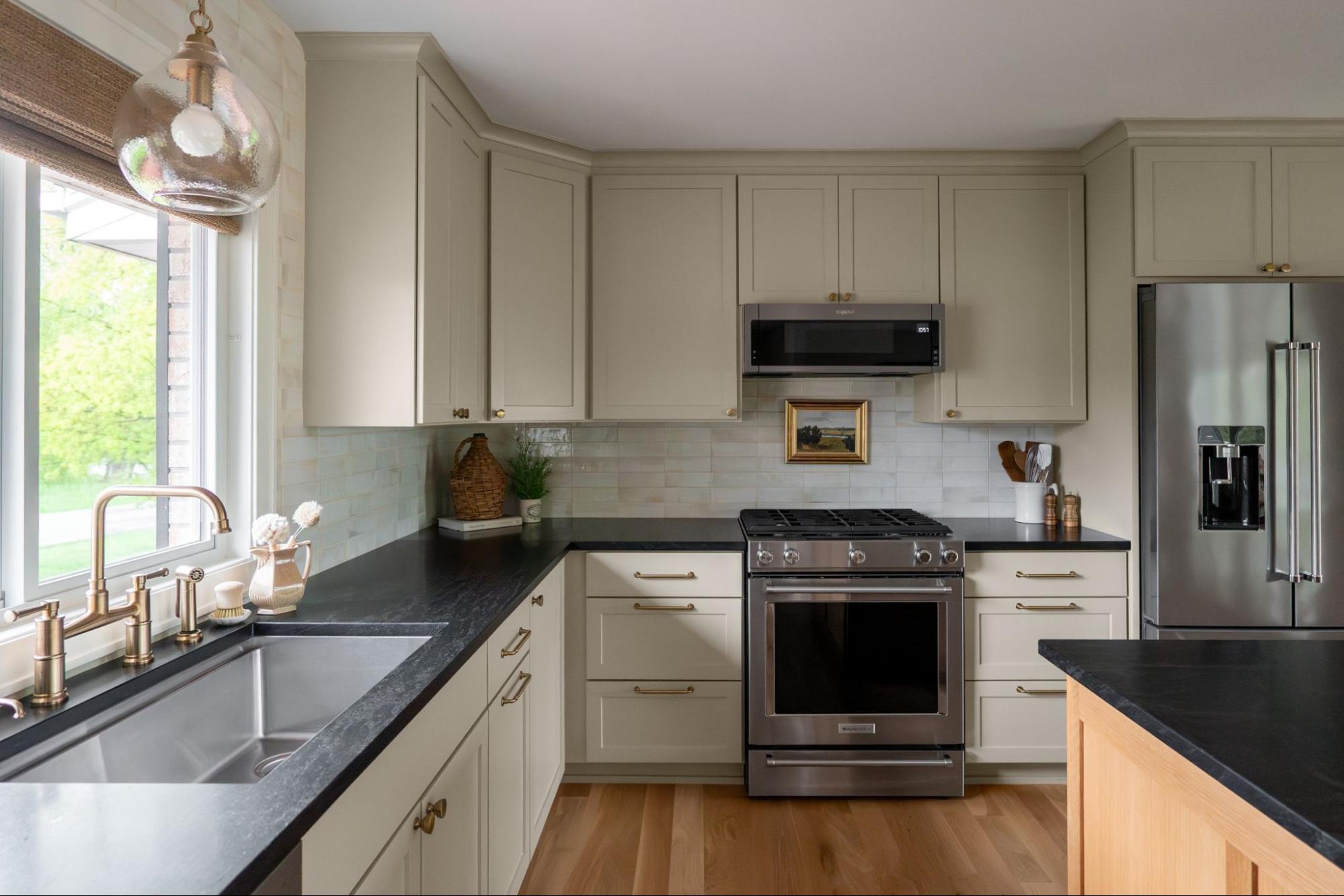 a kitchen with light green cabinets and counters, and a dark marbled countertop