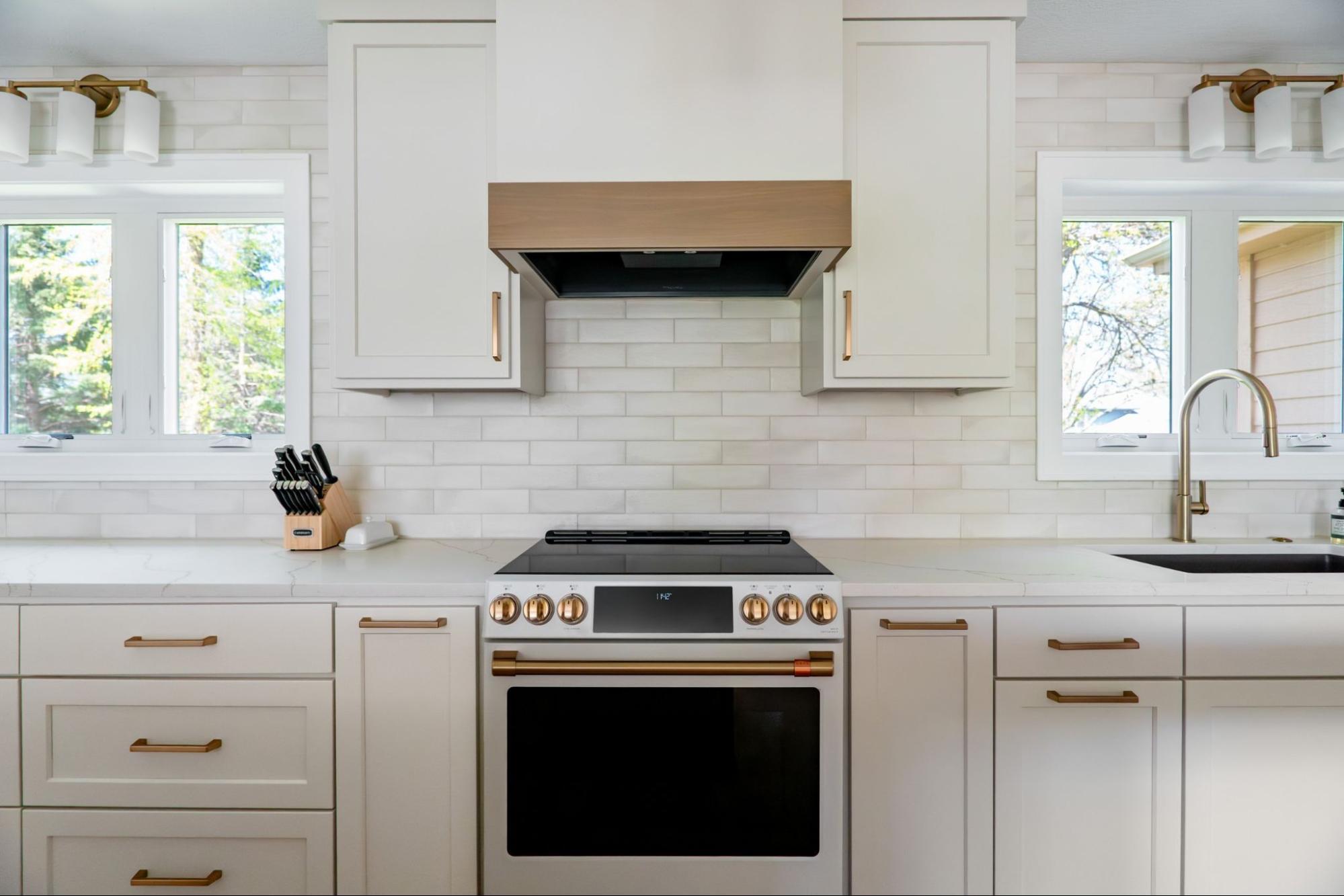 an all-white kitchen: off white cream cabinets, a white countertop, and matching white oven and oven hood