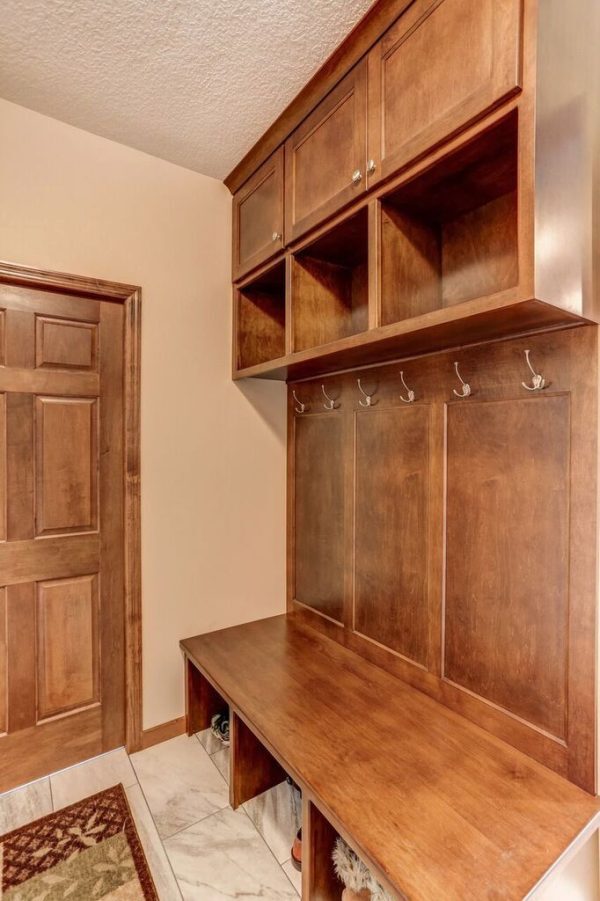 A built-in shelving unit with a bench inside of a mudroom.