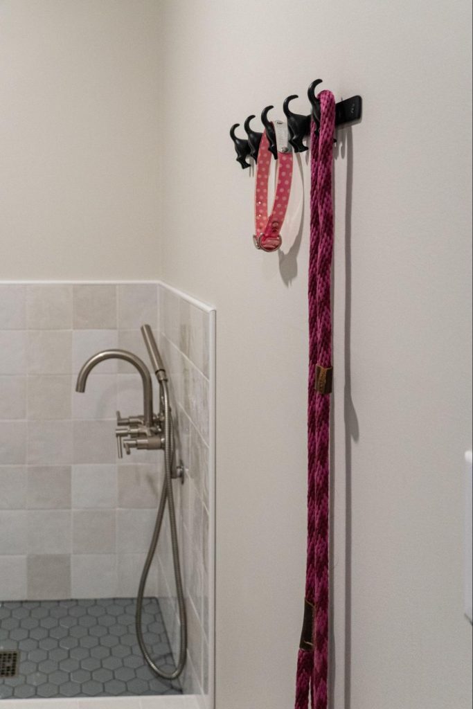a mudroom with a dog washing station. a small tub with a detachable showerhead. Hooks for leash, collar, and harness storage.