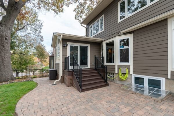 exterior of a home with stone patio and elevated 4 season porch