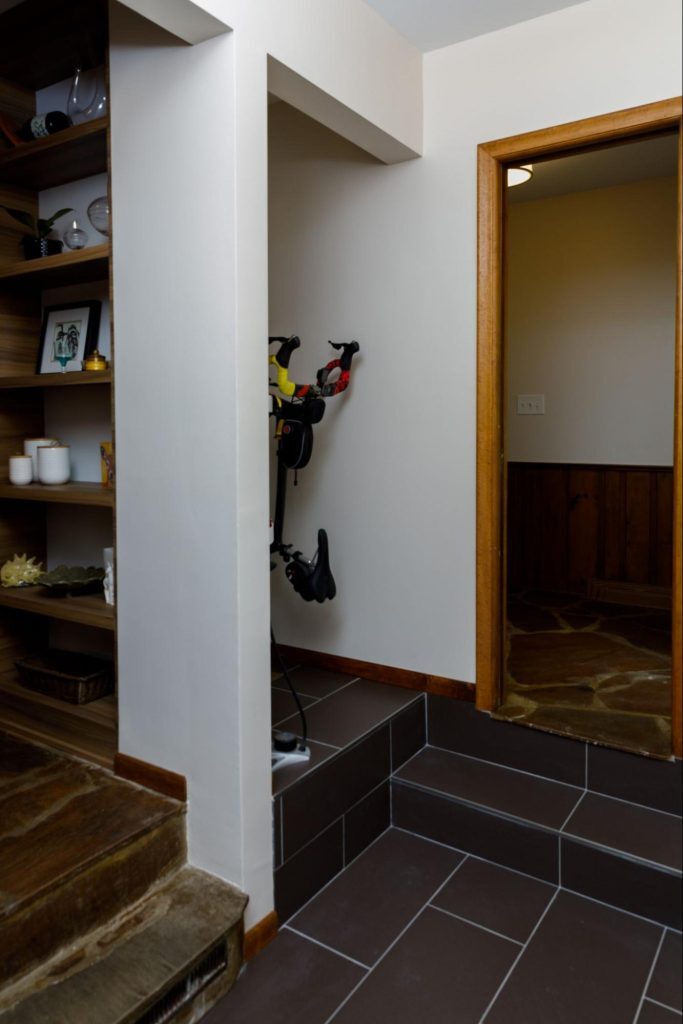 A mudroom with small storage area specifically for bikes.
