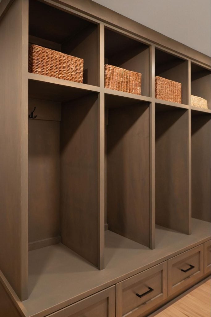 a row of built-in floor to ceiling shelving in a mudroom.