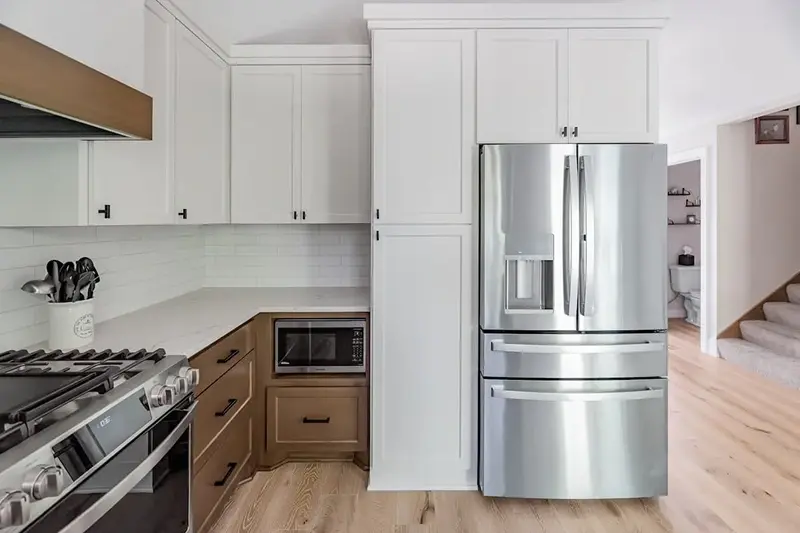 Minnesota kitchen remodel with two-tone white and wood cabinetry, subway tile backsplash, and stainless appliances