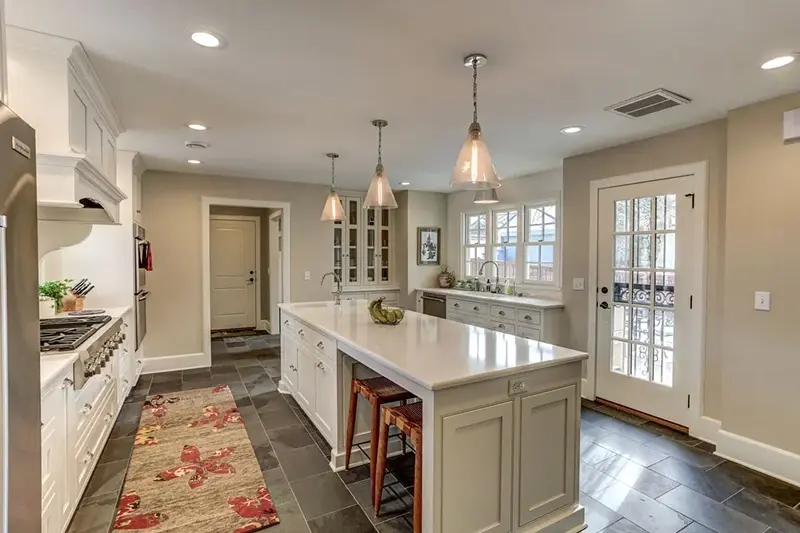 Minnesota kitchen remodel with white shaker cabinets, quartz island, slate tile floor, and French door to backyard