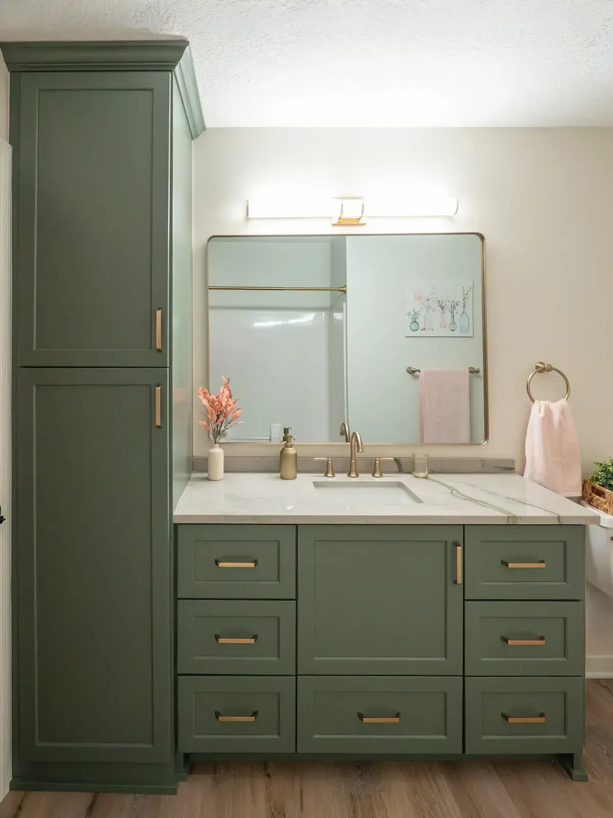 bathroom renovation with painted green cabinets, gold accent hardware