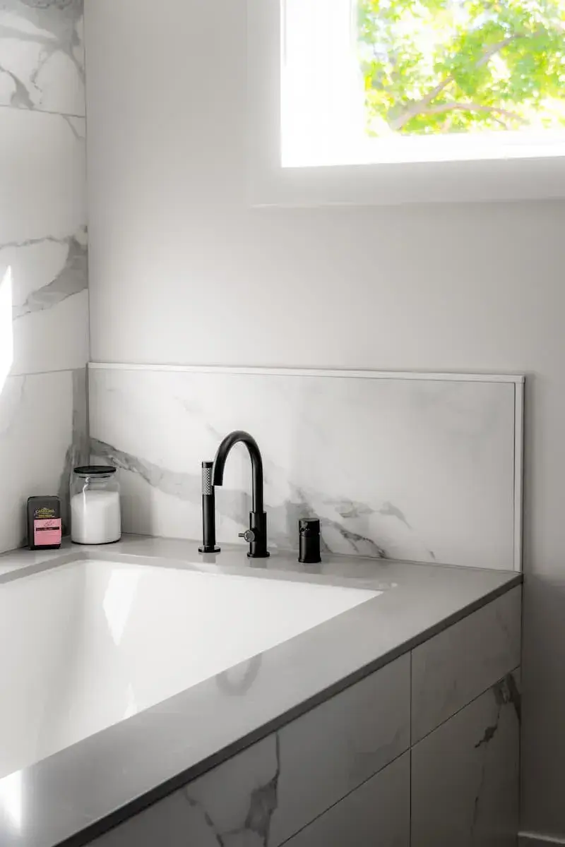 black hardware around a marble tub