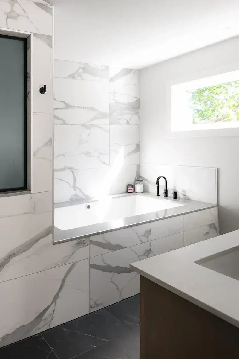 black hardware around a marble tub