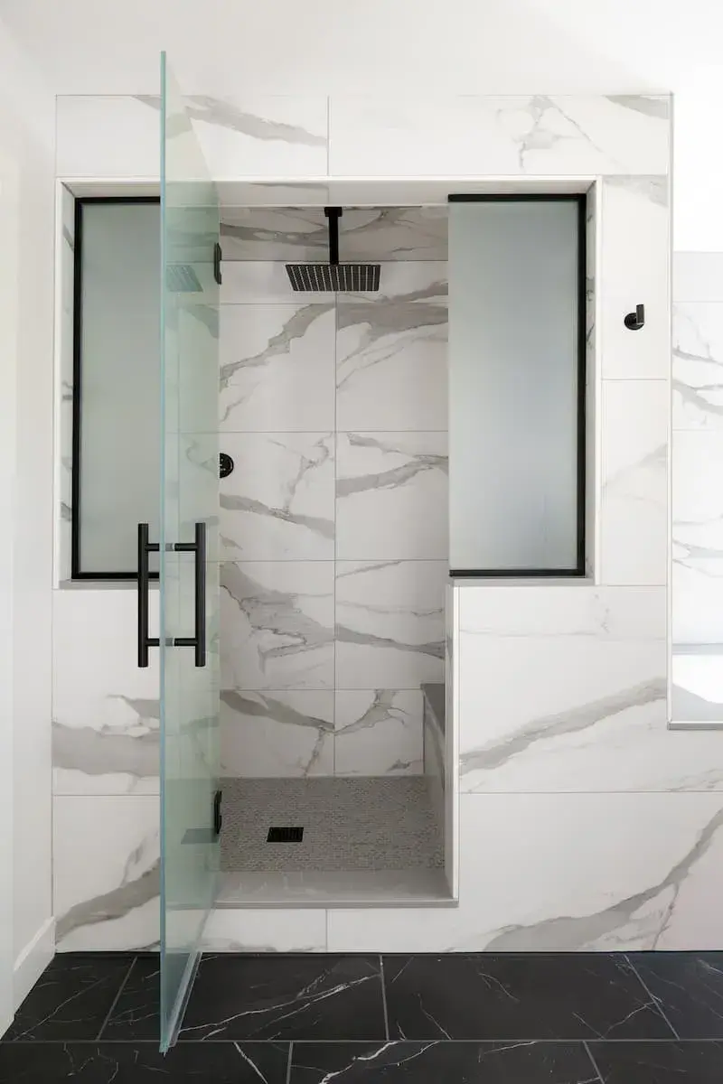 marble shower black hardware and frosted glass