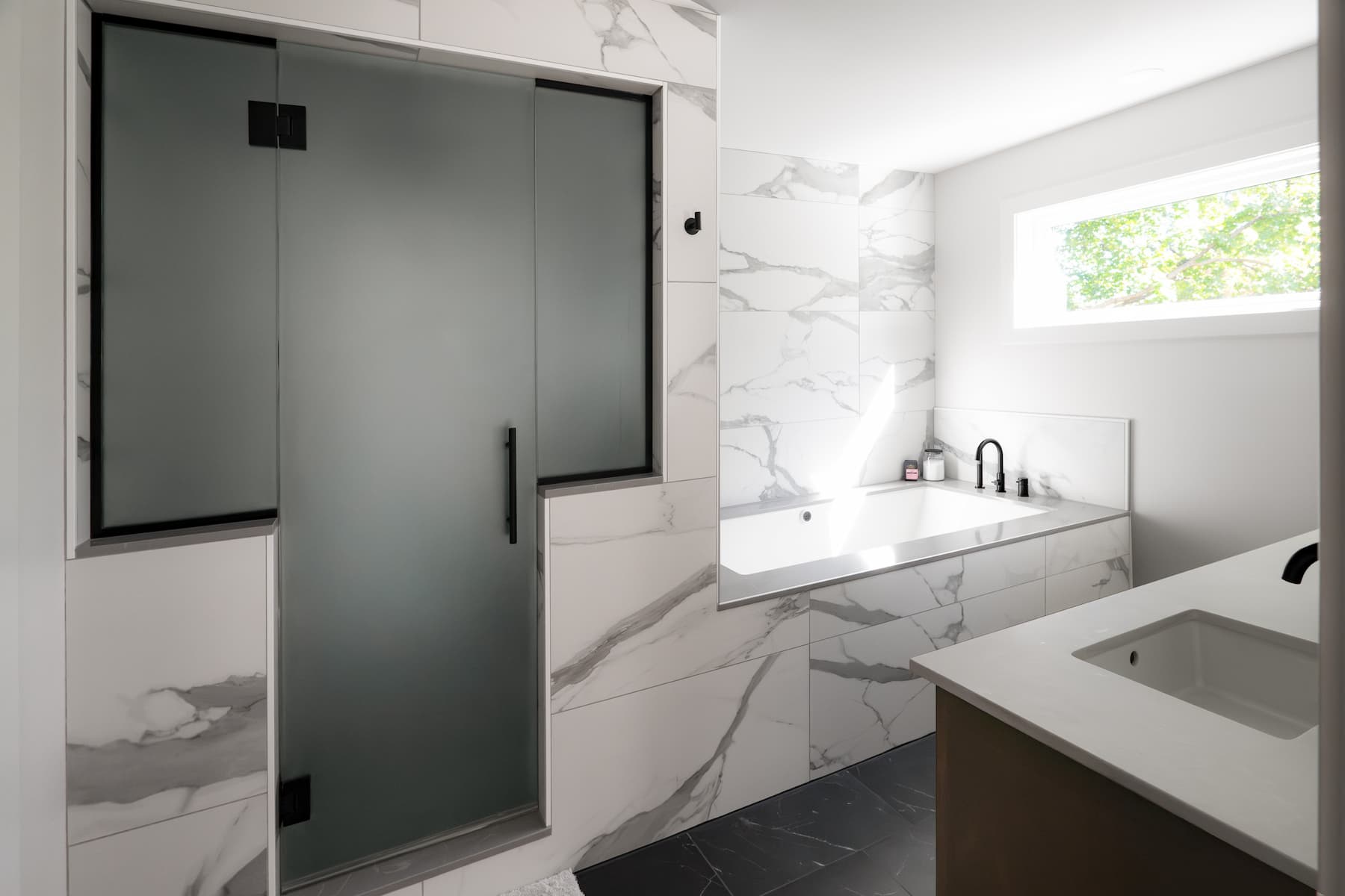 bathroom with a separate shower and tub. large scale marble-inspired tiles create a luxurious look.