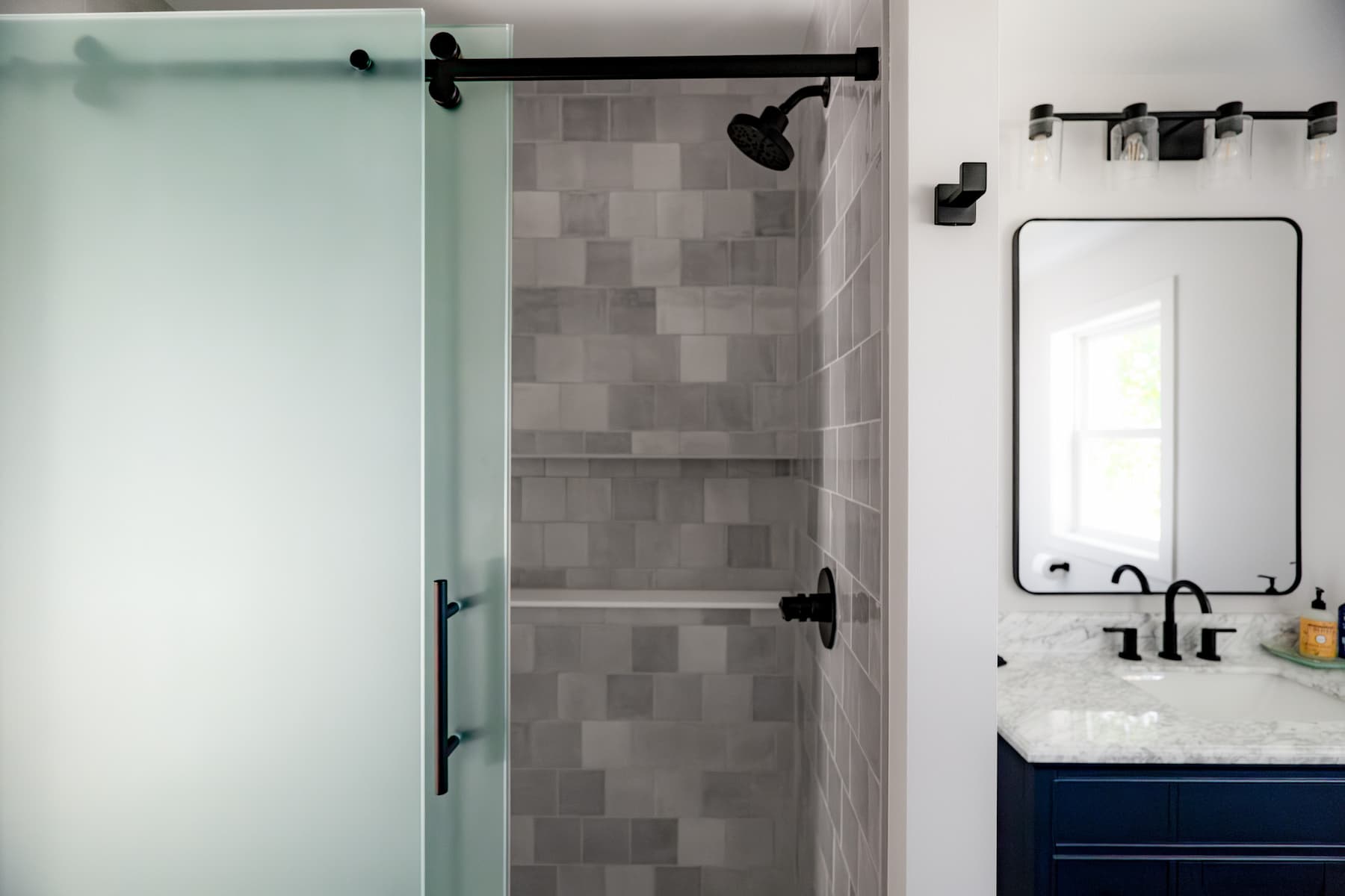 bathroom with large shower and navy blue sink vanity