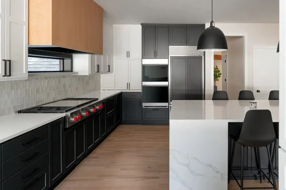 dual ovens with white and black painted cabinetry. waterfall edge kitchen island
