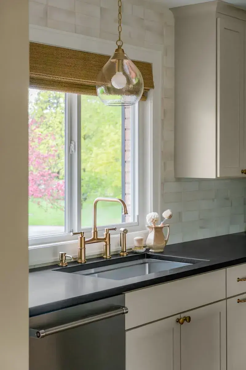 Gold accent and full tile backplash in an updated sunny kitchen