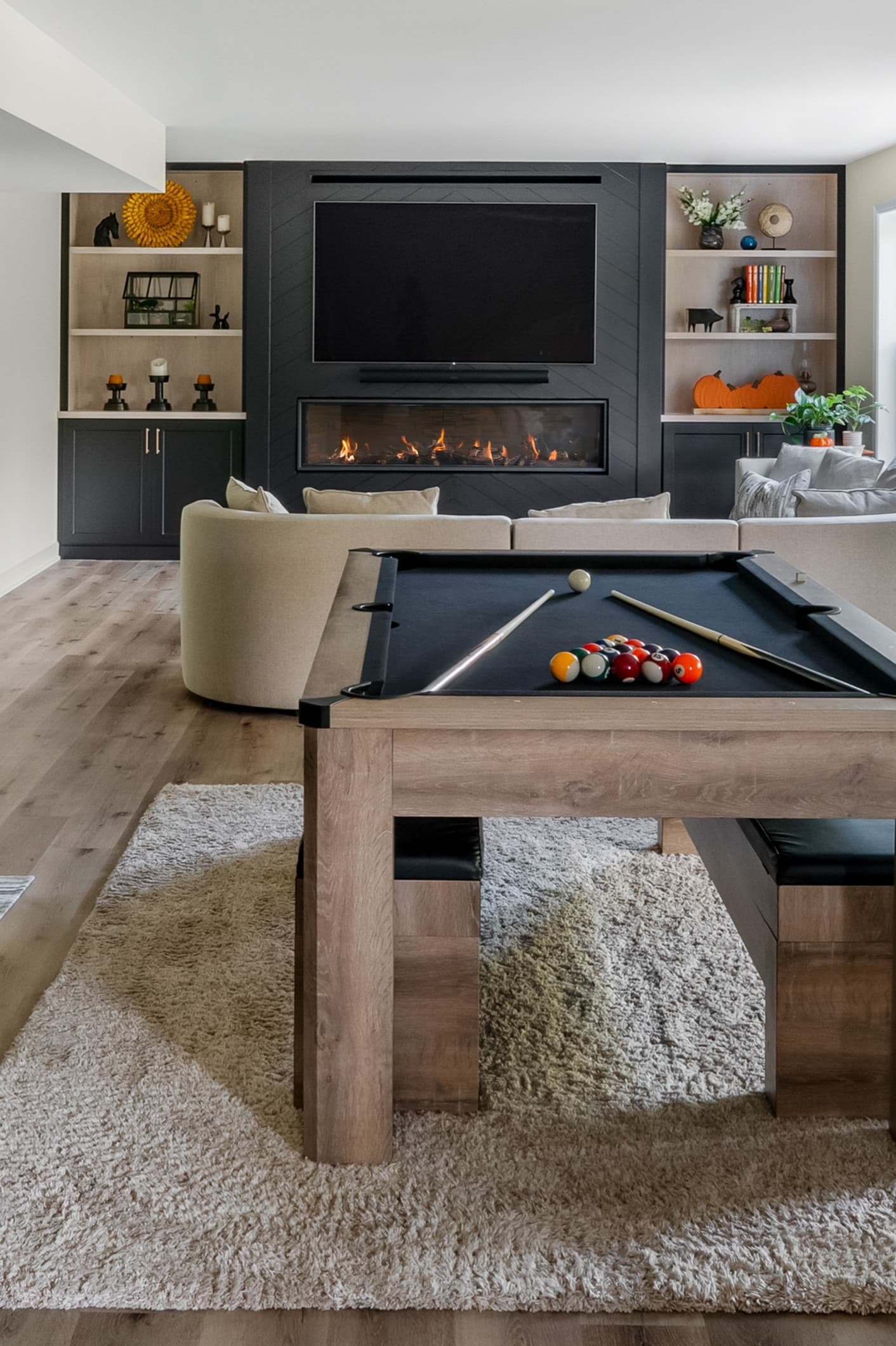 a view of a basement with a pool table, and full wall built-in