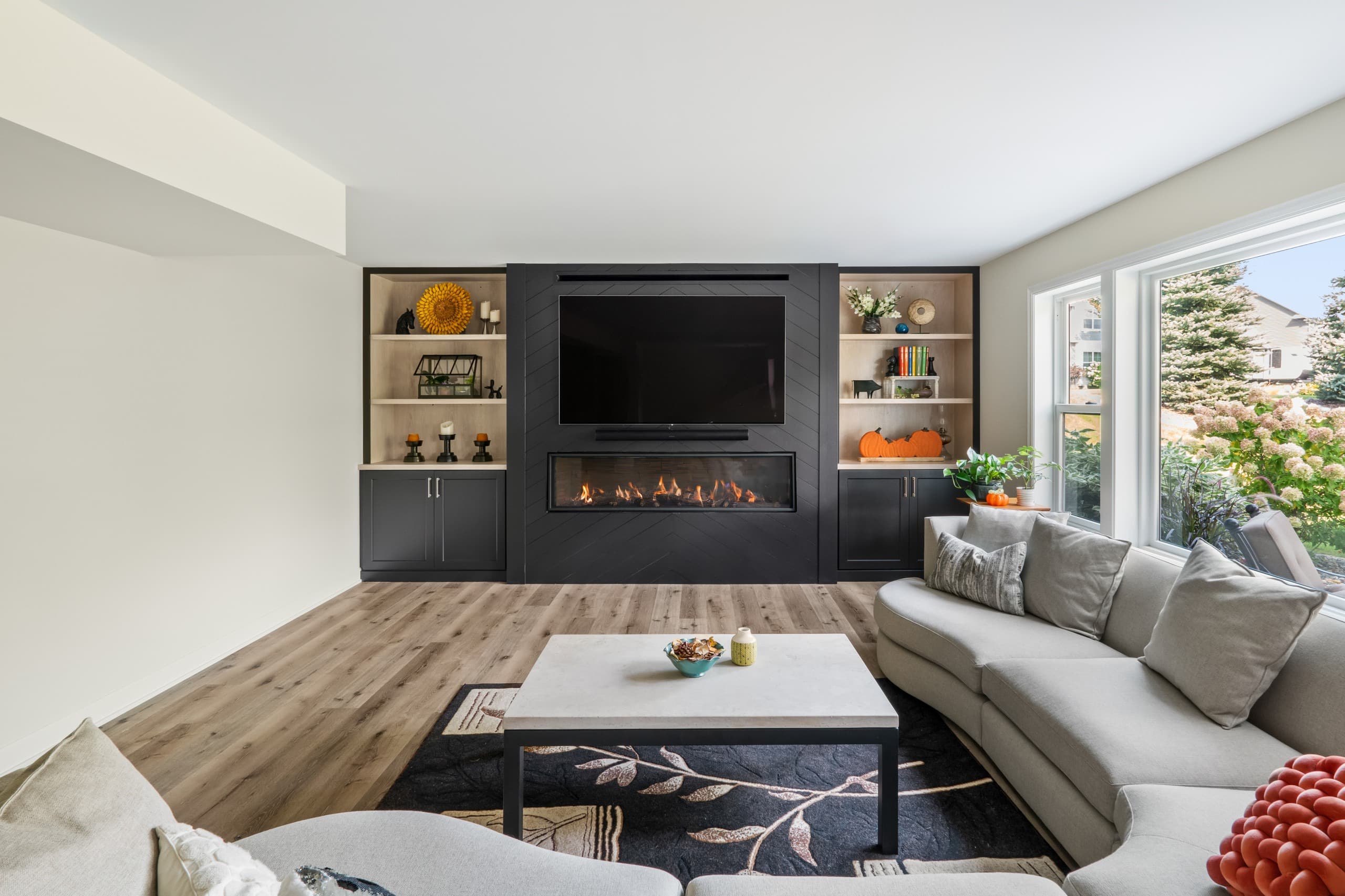 a view of a basement a full wall built-in featuring a fireplace, tv, and shelving