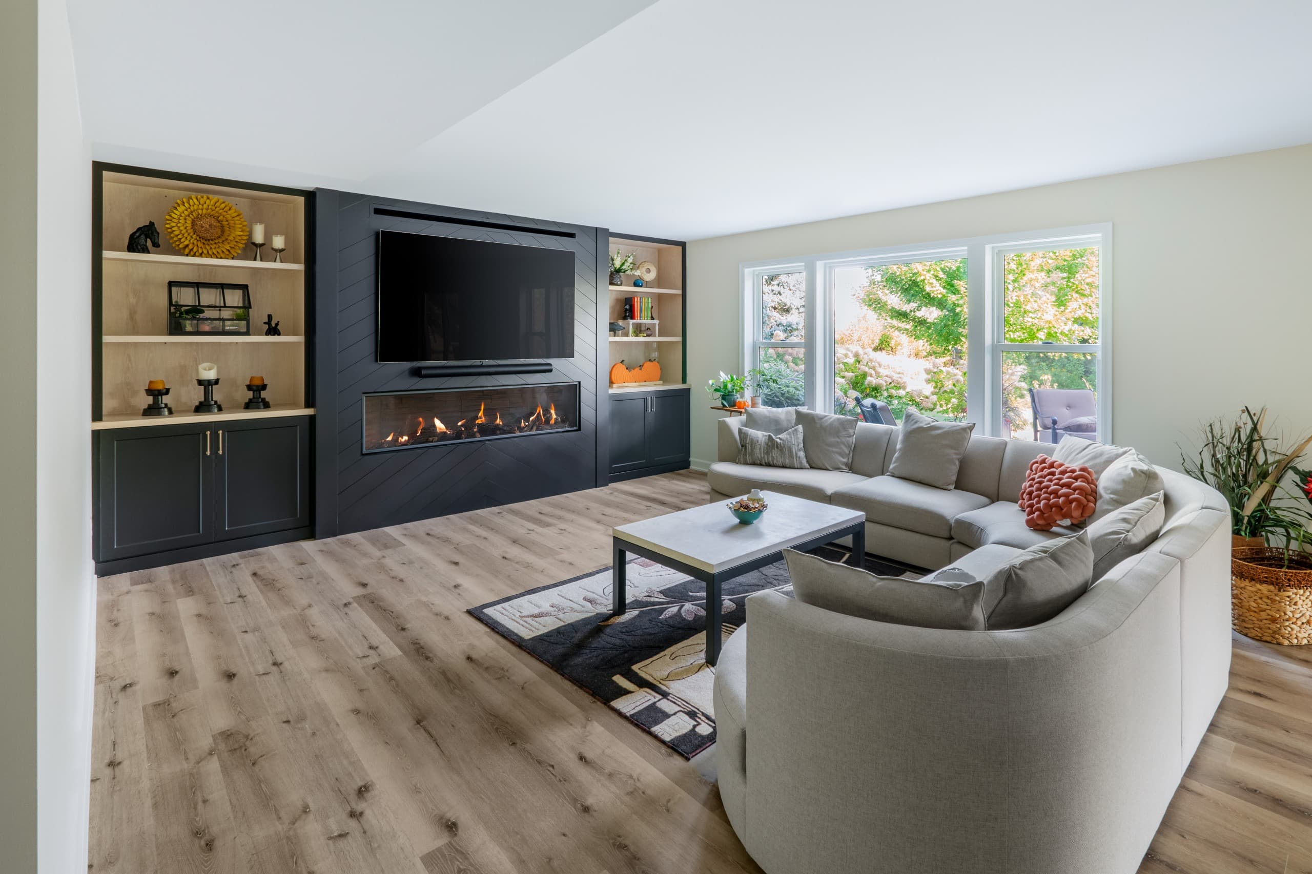 a view of a basement a full wall built-in featuring a fireplace, tv, and shelving