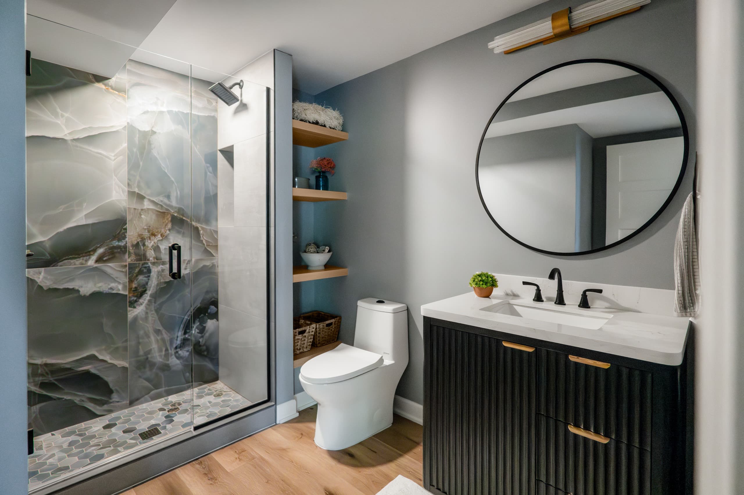 a basement bathroom with blue coloring and marble tiles