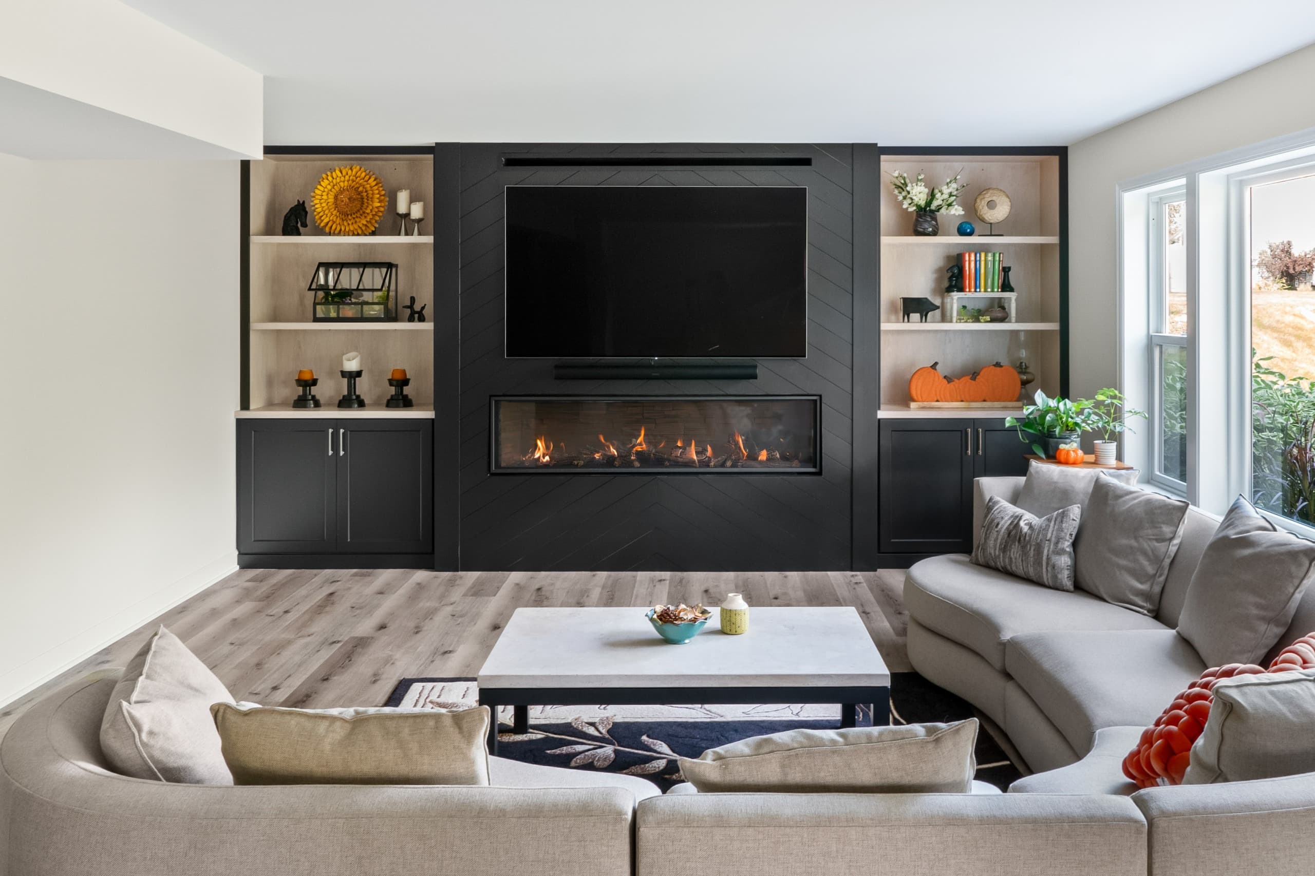 a view of a basement a full wall built-in featuring a fireplace, tv, and shelving
