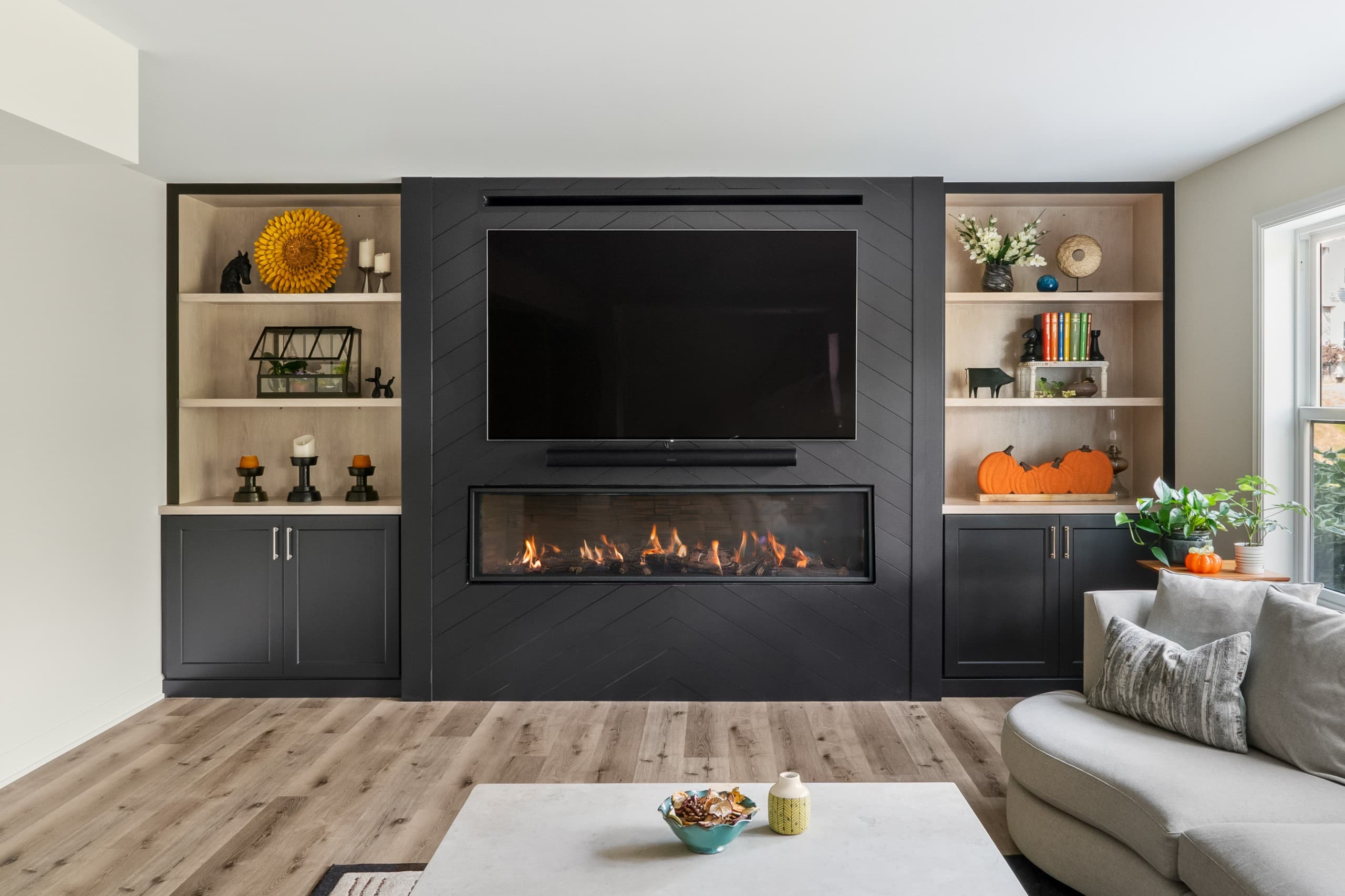 a view of a basement a full wall built-in featuring a fireplace, tv, and shelving
