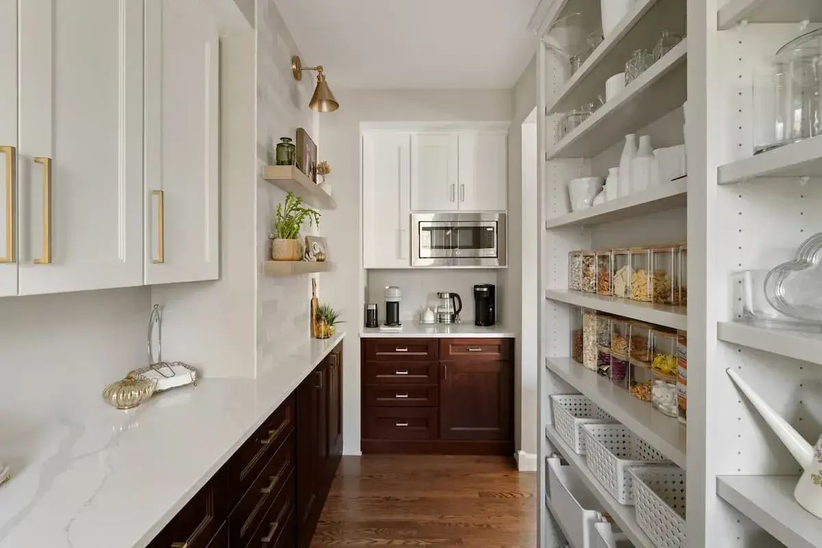 luxurious floor to ceiling cabinets in a walk in pantry with prep sink and workspace