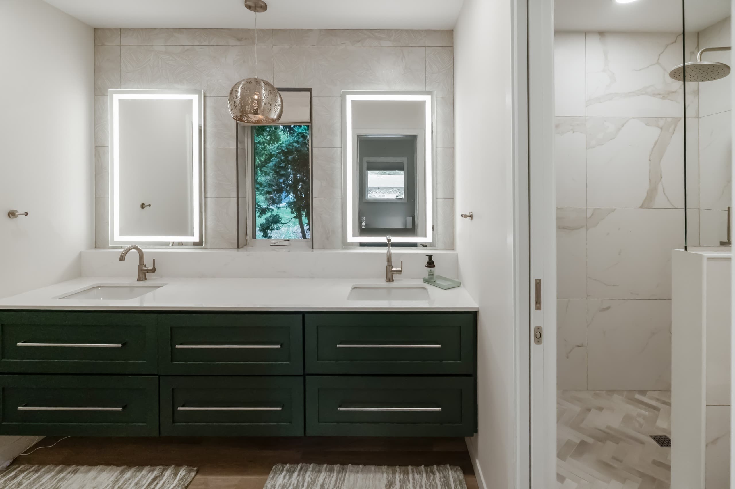 a bathroom with dark green vanity, white countertops, and oversized warm gray stone tiles